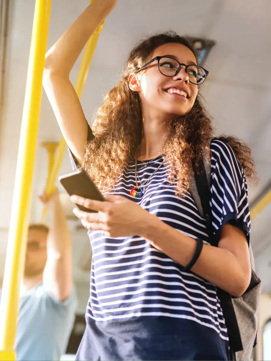 Mujer joven revisando su teléfono en el transporte público